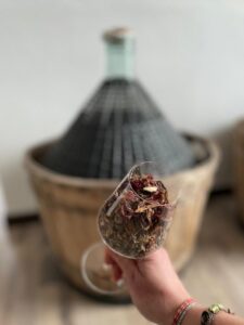 Un calice di botaniche essiccate davanti alla damigiana